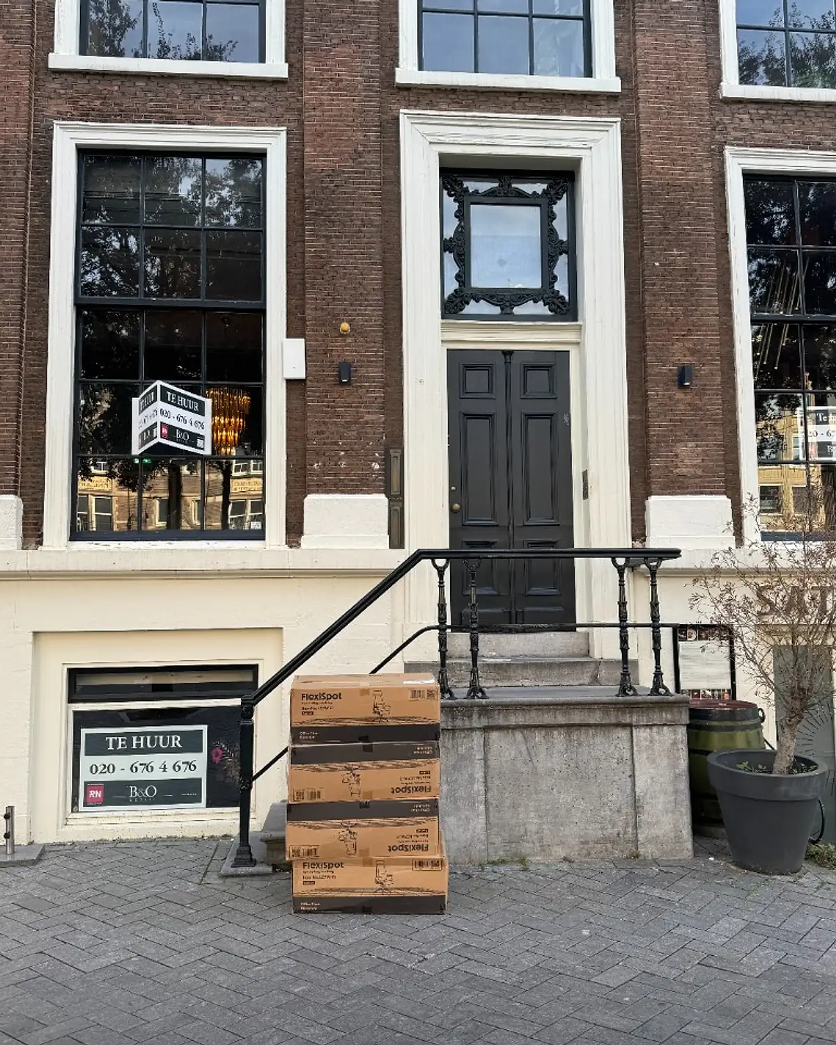 Kartonnen dozen met bureaustoelen voor de deur van Rokin 95